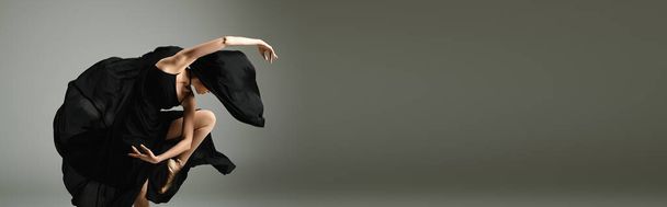 Eine junge, schöne Ballerina tanzt anmutig in einem eleganten schwarzen Kleid. - Foto, Bild