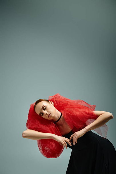 Молодая балерина с рыжими волосами изящно танцует в черном платье. - Фото, изображение