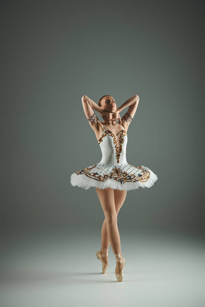 Fiatal, gyönyörű balerina fehér tütüben pózol. - Fotó, kép