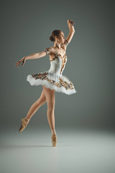 Μια νεαρή, όμορφη μπαλαρίνα με λευκό φόρεμα χορεύει με χάρη.. - Φωτογραφία, εικόνα
