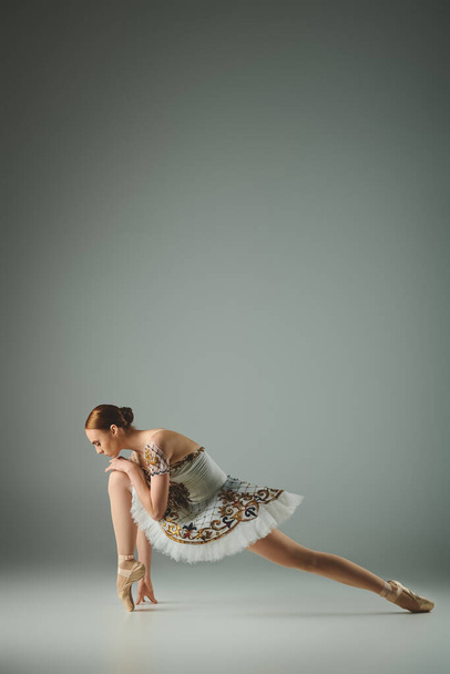 Витончена балерина позує в білій сукні. - Фото, зображення