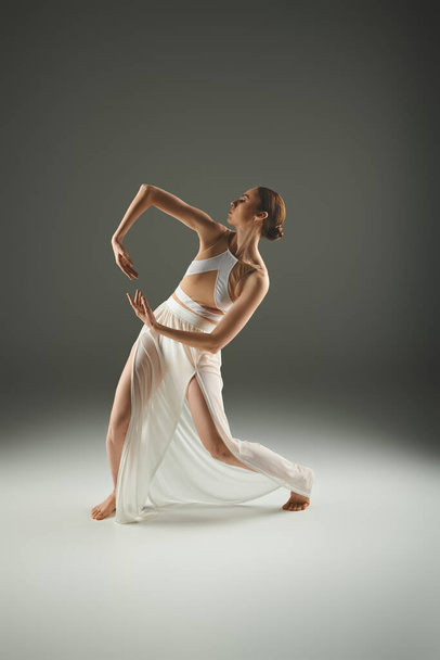 Egy kecses balerina fehér ruhában pózol.. - Fotó, kép