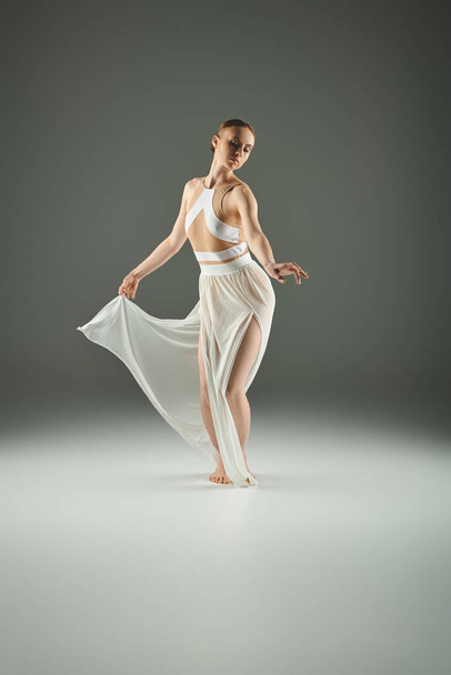 Una hermosa bailarina joven baila con gracia en un vestido blanco. - Foto, imagen