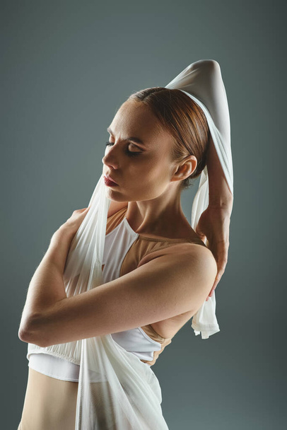 Una bailarina con un vestido blanco sostiene su cabeza. - Foto, Imagen