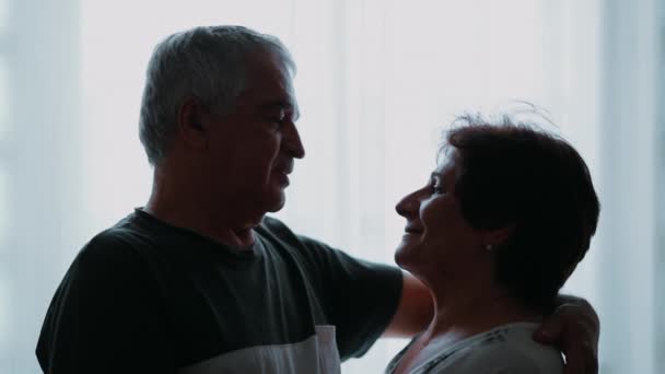 Starší manžel a žena na sebe během stáří láskyplně zírají. starší pár romantický pohled na 70, starší muž s paží kolem ženy - Záběry, video