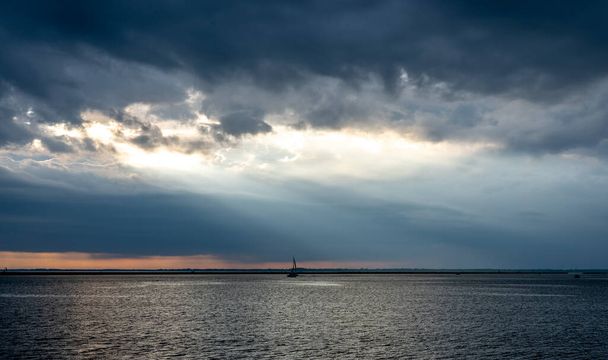 A sailboat on Lake Erie in Buffalo, New York on a stormy evening. - Photo, Image