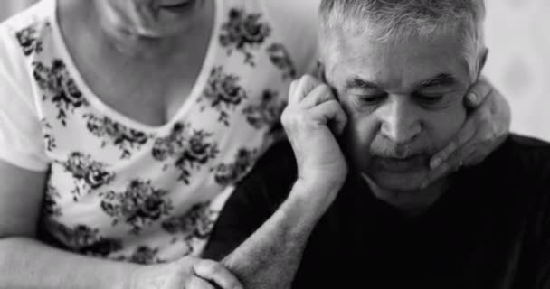 Ηλικιωμένη σύζυγος προσπαθεί να παρηγορήσει τον καταθλιπτικό σύζυγο που παλεύει με ψυχική ασθένεια. Υποστήριξη και φροντίδα ηλικιωμένων κατά τη διάρκεια δύσκολων ετών. ηλικιωμένος σε απόγνωση σε μαύρο και άσπρο - Πλάνα, βίντεο