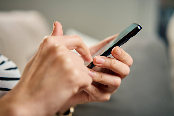Ekranda sosyal medya görüntüsü olan akıllı telefonu rastgele kullanan kişi dijital içerikli bir müdahale öneriyor. Evde cep telefonu kullanan bir kadın - Fotoğraf, Görsel
