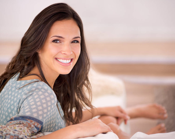 Portrait, couch or happy woman in a house to relax on holiday in hotel, home or apartment living room. Lady, sofa or female person with smile, wellness or confidence on vacation break to rest alone. - Photo, Image