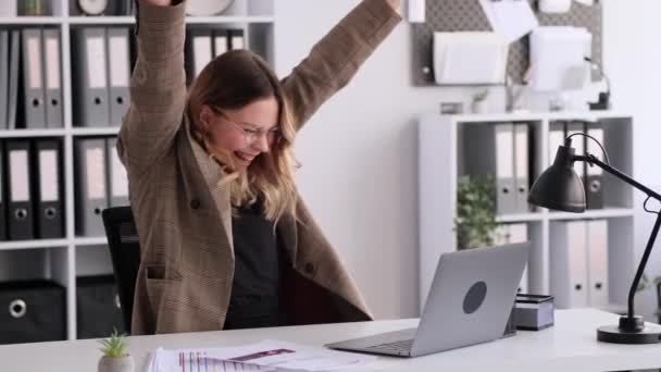Surprised Caucasian woman working with laptop and celebrating success in office. Good news, winning, victory, financial growth concept. - Footage, Video