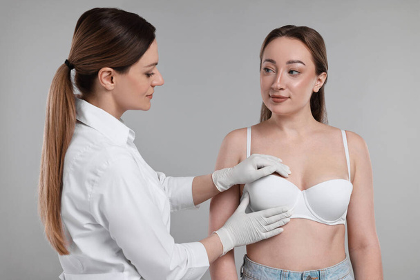 Mammologist checking woman's breast on gray background - Fotografie, Obrázek