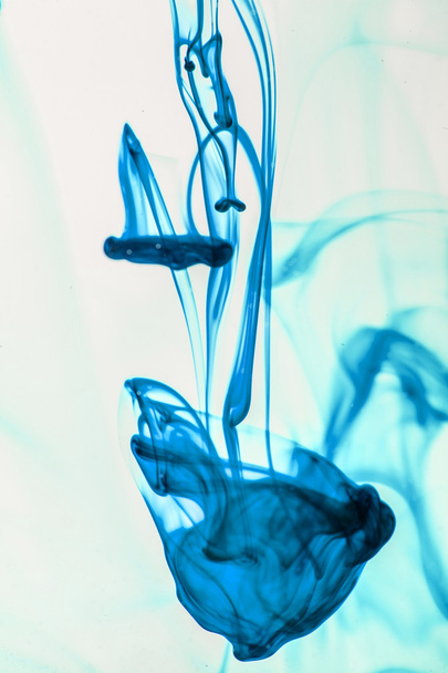 blauw en violet vloeistof in water waardoor abstracte vormen  - Foto, afbeelding