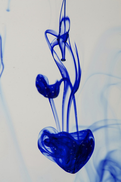 Blue and violet liquid in water making abstract forms  - Zdjęcie, obraz