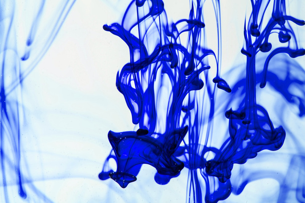 Blue and violet liquid in water making abstract forms  - Photo, Image