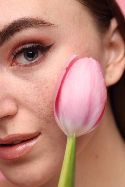 Beautiful woman with fake freckles and tulip, closeup - Foto, imagen