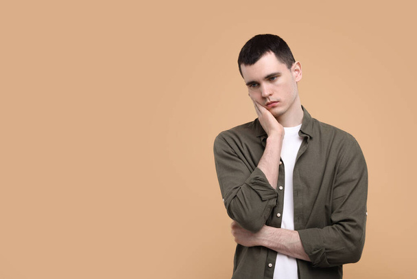 Portrait of sad man on beige background, space for text - Foto, immagini