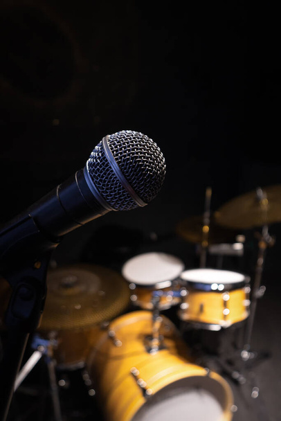 Close-up of the microphone against the background of a blurred drum kit. Vertical photo - Photo, Image