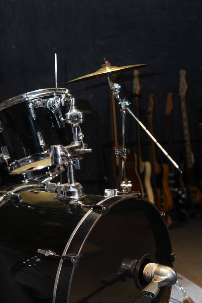 Μέρος ενός drum kit με κύμβαλα σε ένα μουσικό στούντιο, στη σκηνή. Ιστορικό για φωτογραφίες με ζωντανή μουσική, ροκ. Κάθετη φωτογραφία - Φωτογραφία, εικόνα