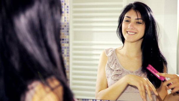 Женщина смотрит на зеркало и расчесывание волос
 - Кадры, видео