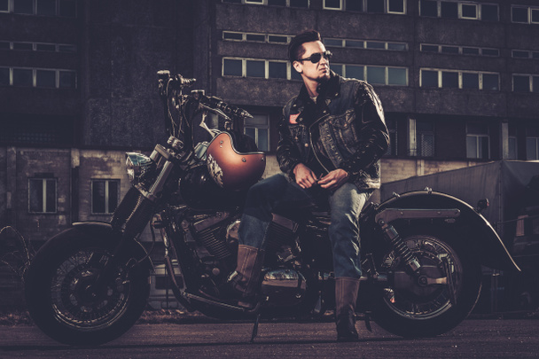 Biker and his bobber style motorcycle on a city streets  - Photo, Image
