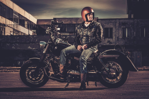 Motociclista e sua motocicleta estilo bobber em uma cidade ruas
  - Foto, Imagem