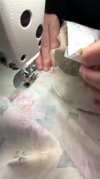 Krawcowa szyjąca przemysłową maszynę do szycia. Zbliżenie procesu szycia tkaniny przez kobietę w produkcji. - Materiał filmowy, wideo