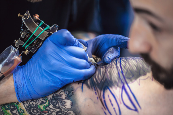 Tattooist makes a tattoo - Zdjęcie, obraz
