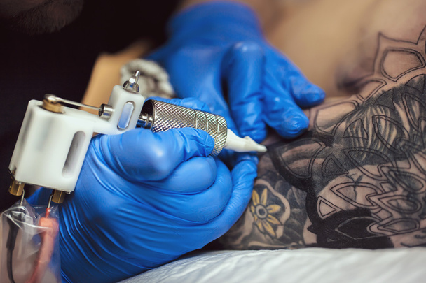 Tattooist makes a tattoo - Foto, imagen