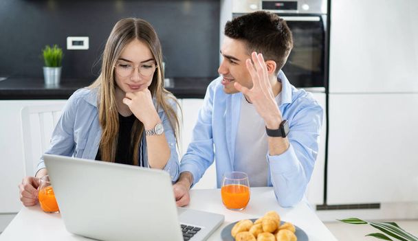 Irritierter und wütender Teenager streitet mit seiner Freundin, während er zu Hause Laptop benutzt - Foto, Bild