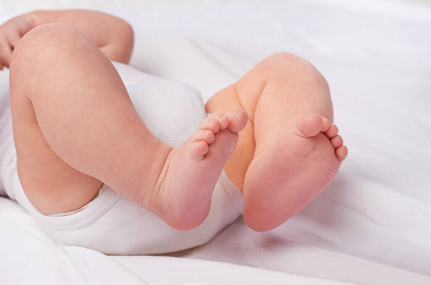Primer plano, bebé recién nacido o pies para relajarse, cama y siesta para una niñez saludable, cuidado y desarrollo. Pie desnudo, pierna y dedos de los pies de un niño pequeño para la calma, el descanso y dormir en una guardería tranquila para soñar. - Foto, imagen