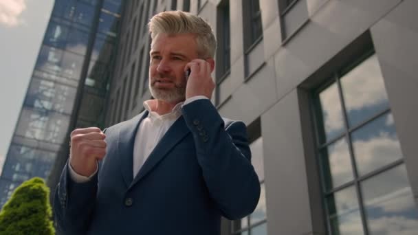 Serious irritated confident emotional entrepreneur talk smartphone conflict explain discussing job problem speaking middle-aged senior business man mature businessman in city talking mobile phone call - Footage, Video
