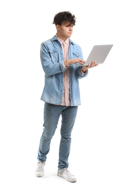 Étudiant masculin utilisant un ordinateur portable sur fond blanc - Photo, image