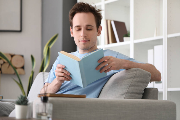 Estudante do sexo masculino leitura livro em casa - Foto, Imagem