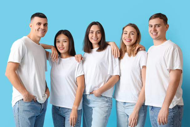 Grupa młodych ludzi w stylowych dżinsach na niebieskim tle - Zdjęcie, obraz
