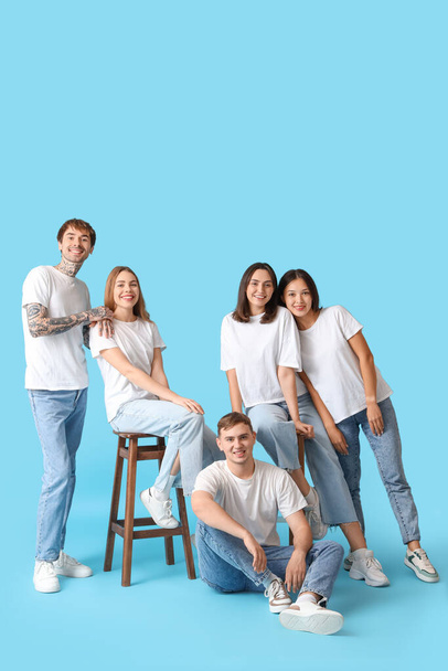 Group of young people in stylish jeans on blue background - Photo, Image