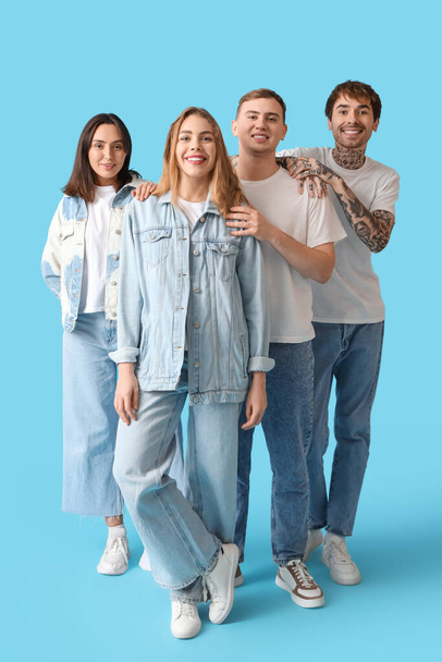 Group of young people in stylish jeans on blue background - Fotoğraf, Görsel