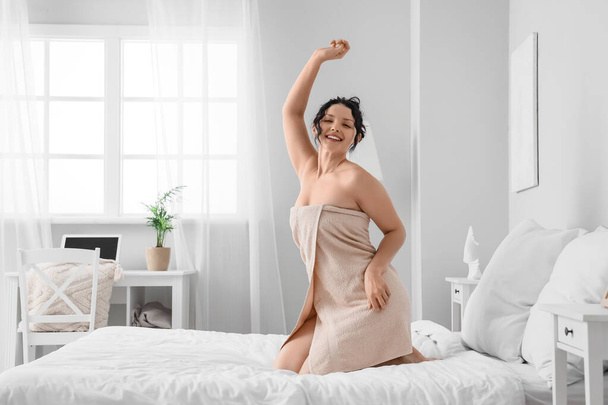 gelukkig jong vrouw dragen handdoek na douche in slaapkamer - Foto, afbeelding