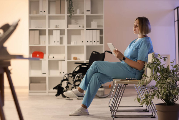 Enfermeira com computador tablet trabalhando turno da noite na clínica - Foto, Imagem
