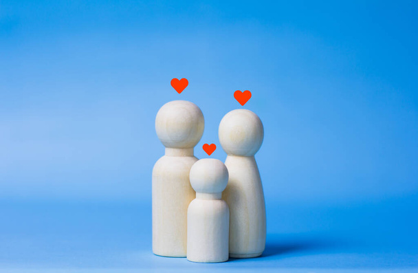 Family wooden dolls on blue background Life insurance ideas for future financial security and protection plans for life security. - Photo, Image