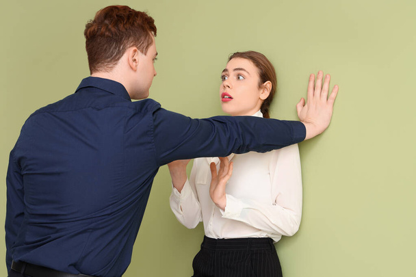 Homme d'affaires molester sa collègue féminine sur fond vert. Concept de harcèlement - Photo, image