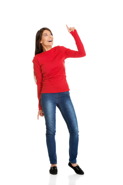 Smiling woman pointing up. - 写真・画像