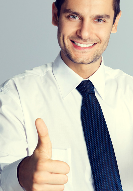 Young smiling businessman with thumbs up gesture - Foto, imagen
