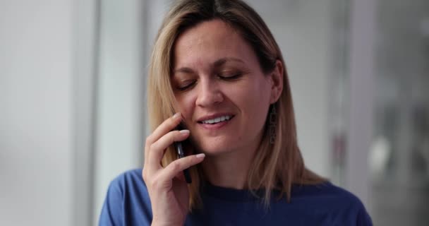 Жінка потрапляє в лоб з рукою, розмовляючи по смартфону з пацієнтом в лікарняному кабінеті. Розгубленість і сором за невідповідне ставлення до клієнта вдома повільний рух - Кадри, відео