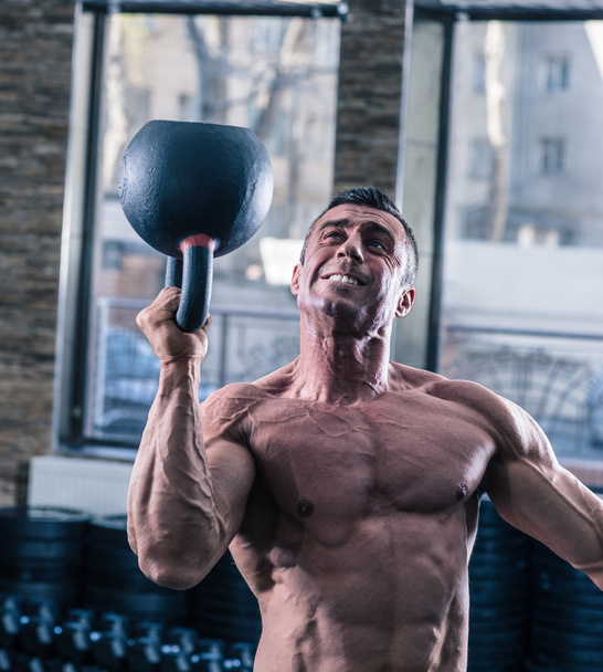 Bodybuilder man workout with kettle ball - Valokuva, kuva