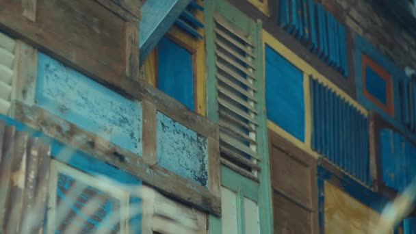 Πολύχρωμα ξύλινα παντζούρια σε ρουστίκ πρόσοψη σπιτιού, που απεικονίζουν ξεπερασμένες υφές και vintage αρχιτεκτονικές λεπτομέρειες κατά τη διάρκεια της ημέρας - Πλάνα, βίντεο