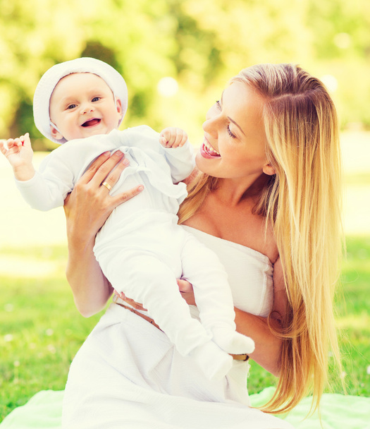 glückliche Mutter mit kleinem Baby auf Decke sitzend - Foto, Bild