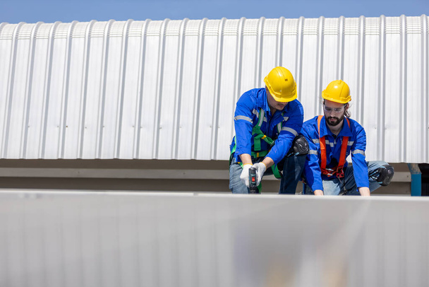 Les ingénieurs installent et inspectent les normes des panneaux solaires sur le toit d'une usine industrielle. Équipe technicien d'inspection et de réparation de la technologie cellule solaire. Alternative innovation puissance environnement. - Photo, image