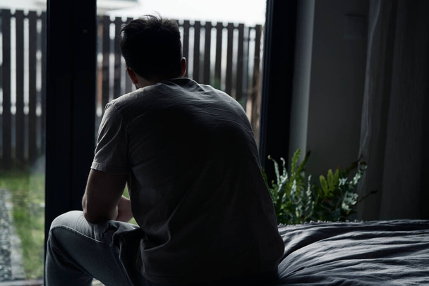 Rückenansicht eines depressiven Mannes zu Hause - Foto, Bild