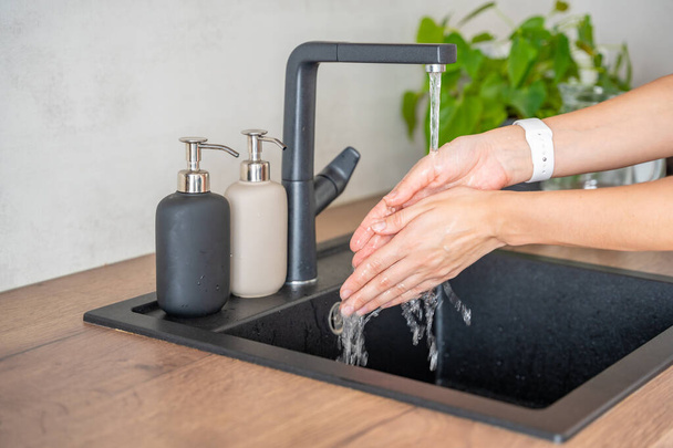 Mulher lava as mãos e usa sabão de garrafa reutilizável. Estilo de vida ecológico. Foto de alta qualidade - Foto, Imagem