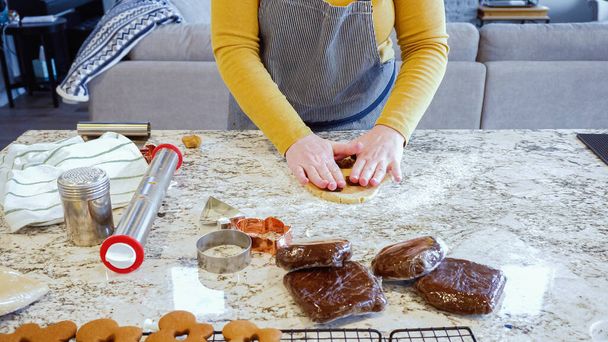 現代の台所のエレガントな大理石のカウンターでジンジャーブレッドクッキー生地をロールアウトするために調整可能なローリングピンを使用して,お祝いの休日のベーキングの準備をします. - 写真・画像
